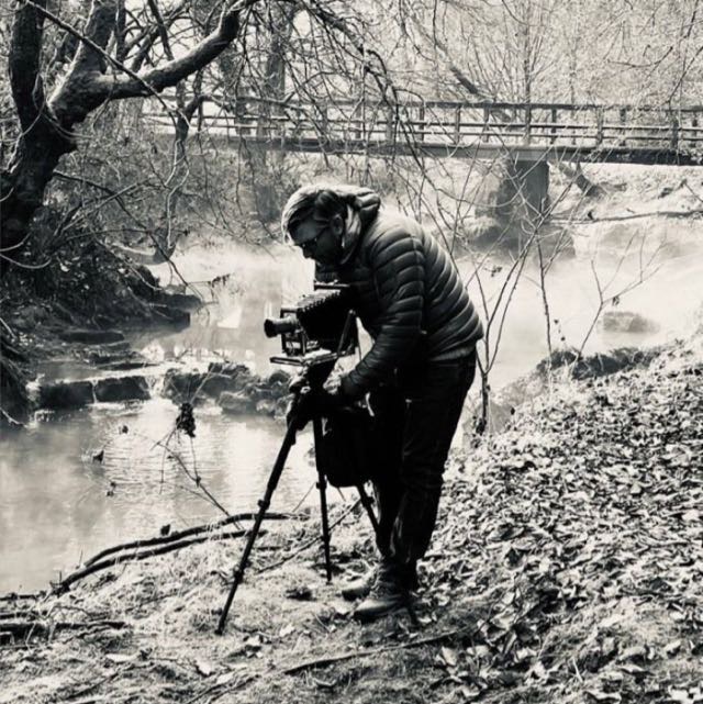 Achim Boers working with a large-format camera beside a stream